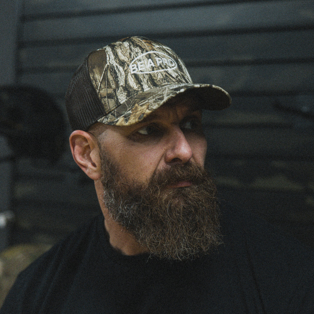 GBRS Group Be A Pro Trucker Hat in Realtree Camo - lifestyle image showing side of hat