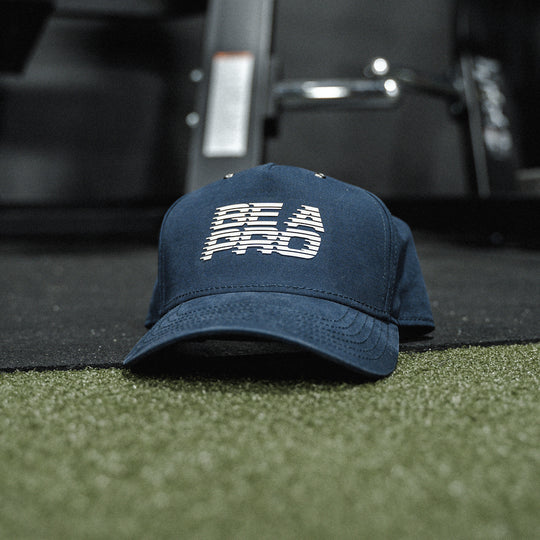 GBRS Group Be A Pro Canvas Trucker Hat Pictured in a gym background