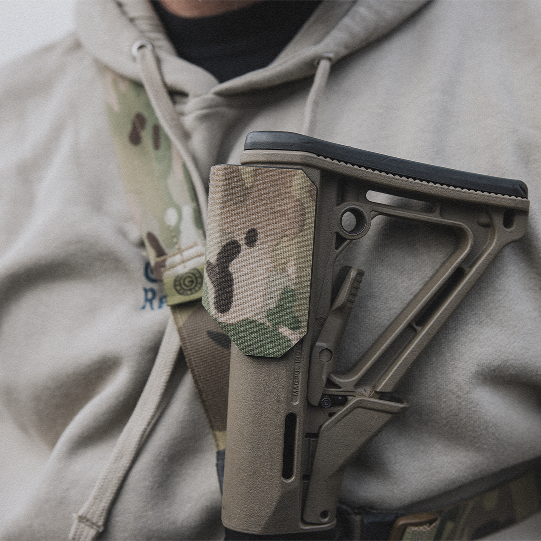 Multicam Cheek Riser close up, hanging off a sling on a model