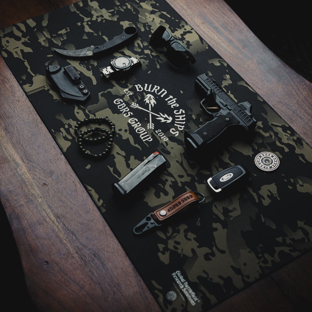 GBRS Group Burn The Ships Work Mat - Lifestyle image on a desk with random items on top