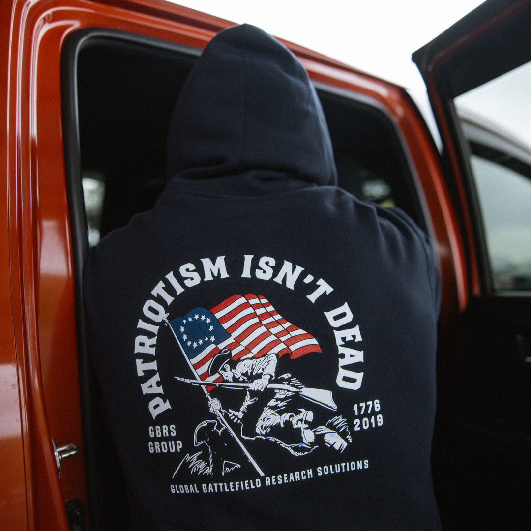 GBRS Group Patriotism Isn't Dead Zip Up Hoodie on a model showing Screen printed Patriotism Isn't Dead backprint design in a lifestyle environment