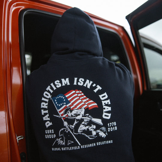 GBRS Group Patriotism Isn't Dead Zip Up Hoodie on a model showing Screen printed Patriotism Isn't Dead backprint design in a lifestyle environment
