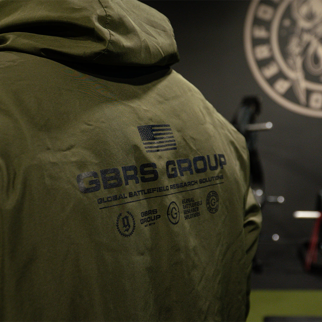 GBRS Group Instructor Windbreaker Jacket - Anniversary Edition. Half zip pull-over, water resistant, windbreaker jacket. - Lifestyle in a gym - close up of the back print