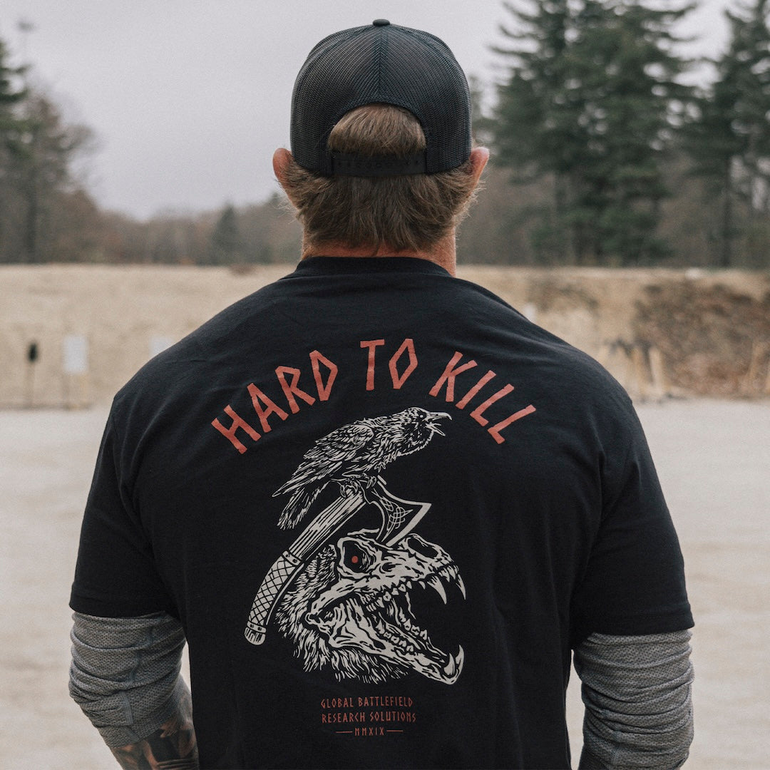 Model wearing the GBRS Group Hard to Kill Death Grip Short Sleeve in an outdoor environment, showing the design on the back