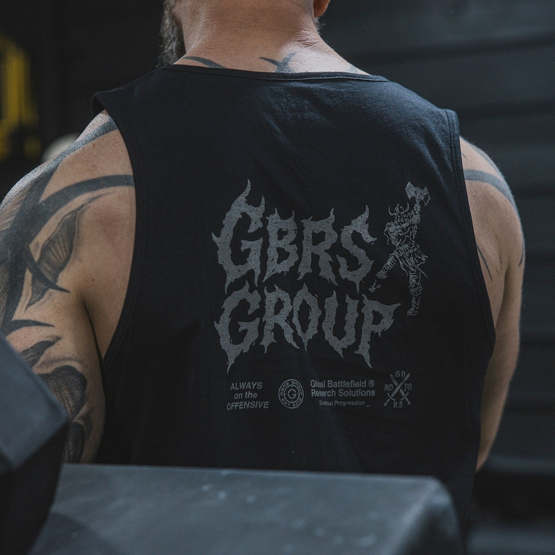 Person wearing a black tank top with 'GBRS GROUP' printed on the back in a gym.