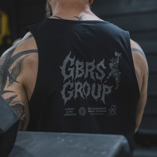 Person wearing a black tank top with 'GBRS GROUP' printed on the back in a gym.