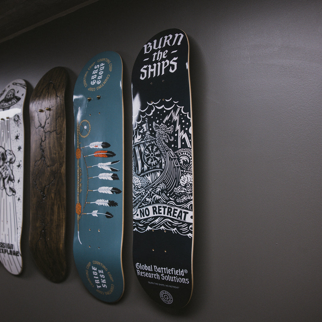 GBRS Group Burn The Ships Skateboard Deck lifestyle image pictured hanging on a wall with other skateboard decks