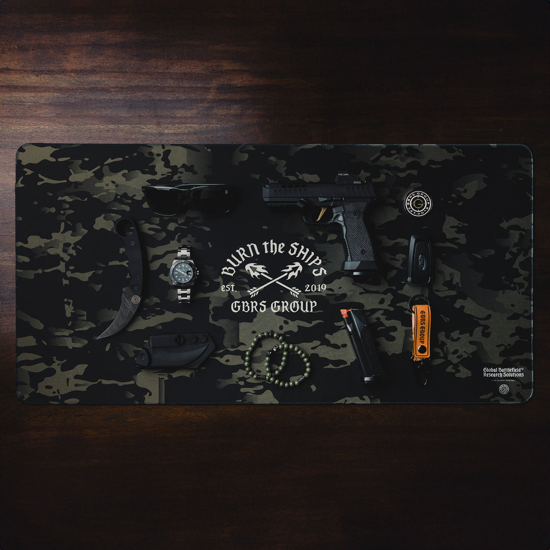 GBRS Group Burn The Ships Work Mat - Lifestyle image on a desk with random items on top