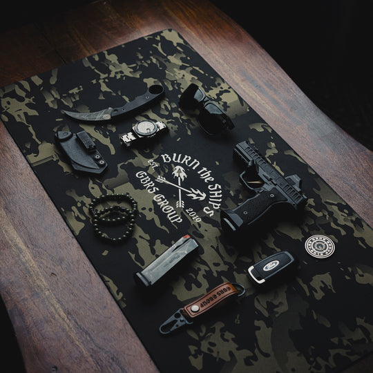 GBRS Group Burn The Ships Work Mat - Lifestyle image on a desk with random items on top