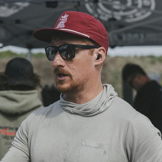 Man wearing a red and white cap and sunglasses