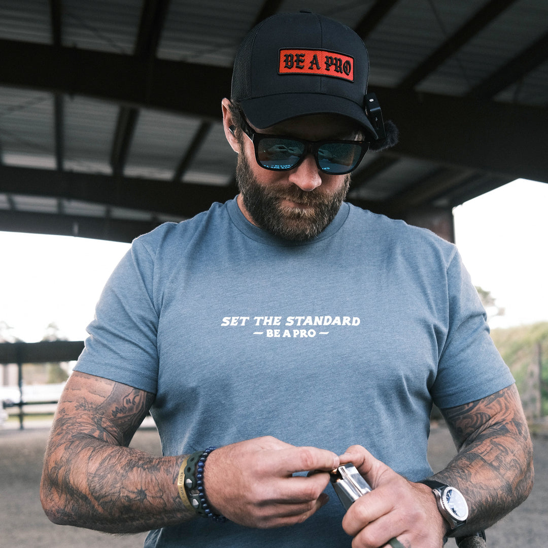 GBRS Group Set The Standard Short Sleeve Shirt. Lifestyle shot at the range. Be A Pro - A mindset to elevate your performance, keep you focused, and help spark motivation in others to foster the same mentality.