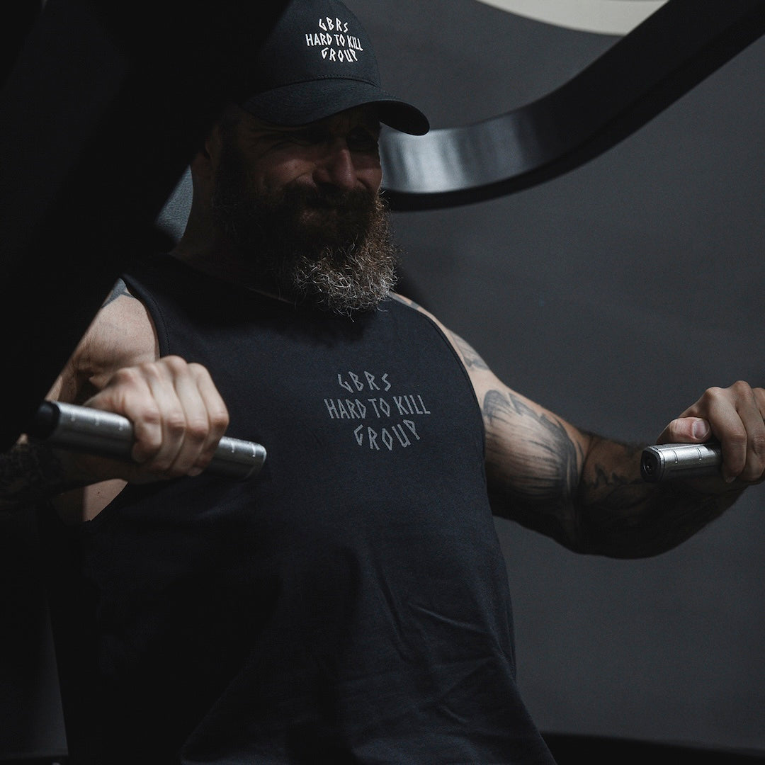 Man wearing GBRS Hard to Kill Axe and Talon Tank in a gym and performing a workout