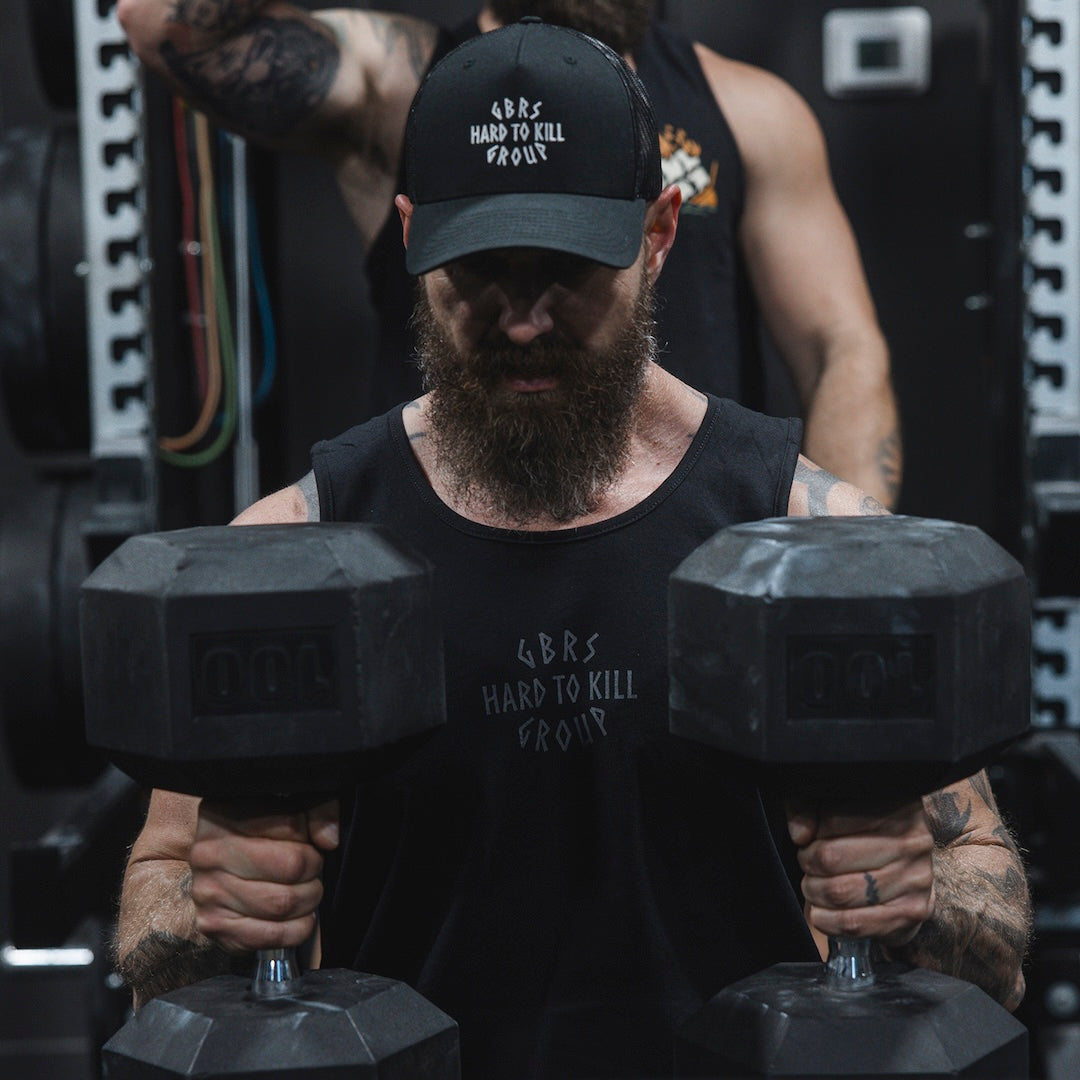 Man wearing GBRS Hard to Kill Axe and Talon Tank in a gym and performing a workout