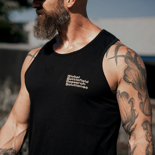 Man walking outside while wearing the GBRS Group Bravado Tank Top, showing the graphic design on the left chest area..