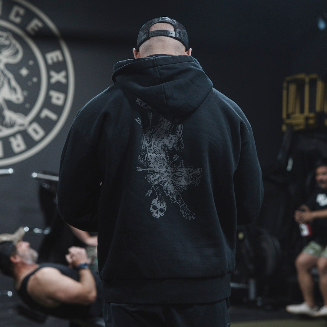 Man wearing the GBRS Group Hard to Kill Oversized Hoodie in a gym, showing the back design