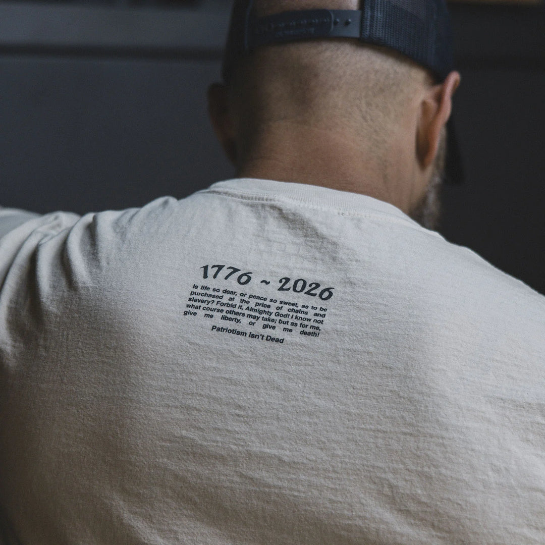 Person wearing the GBRS Group Front and Center Long Sleeve Shirt with text on the back, standing indoors.