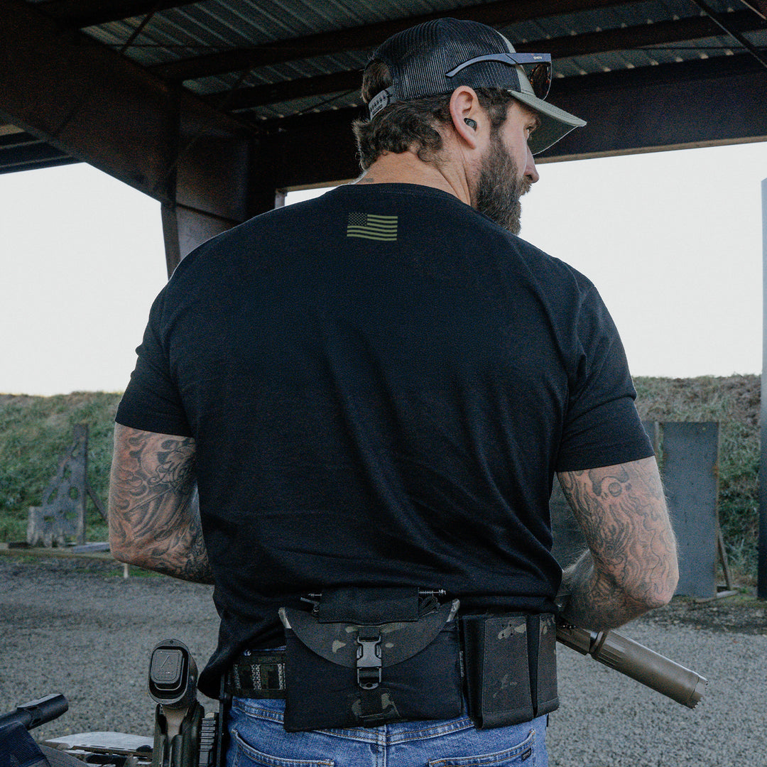 Man at an outdoor range wearing a black GBRS t-shirt