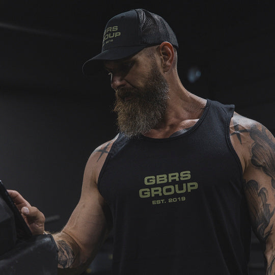 Man wearing a GBRS tank top and hat in the gym