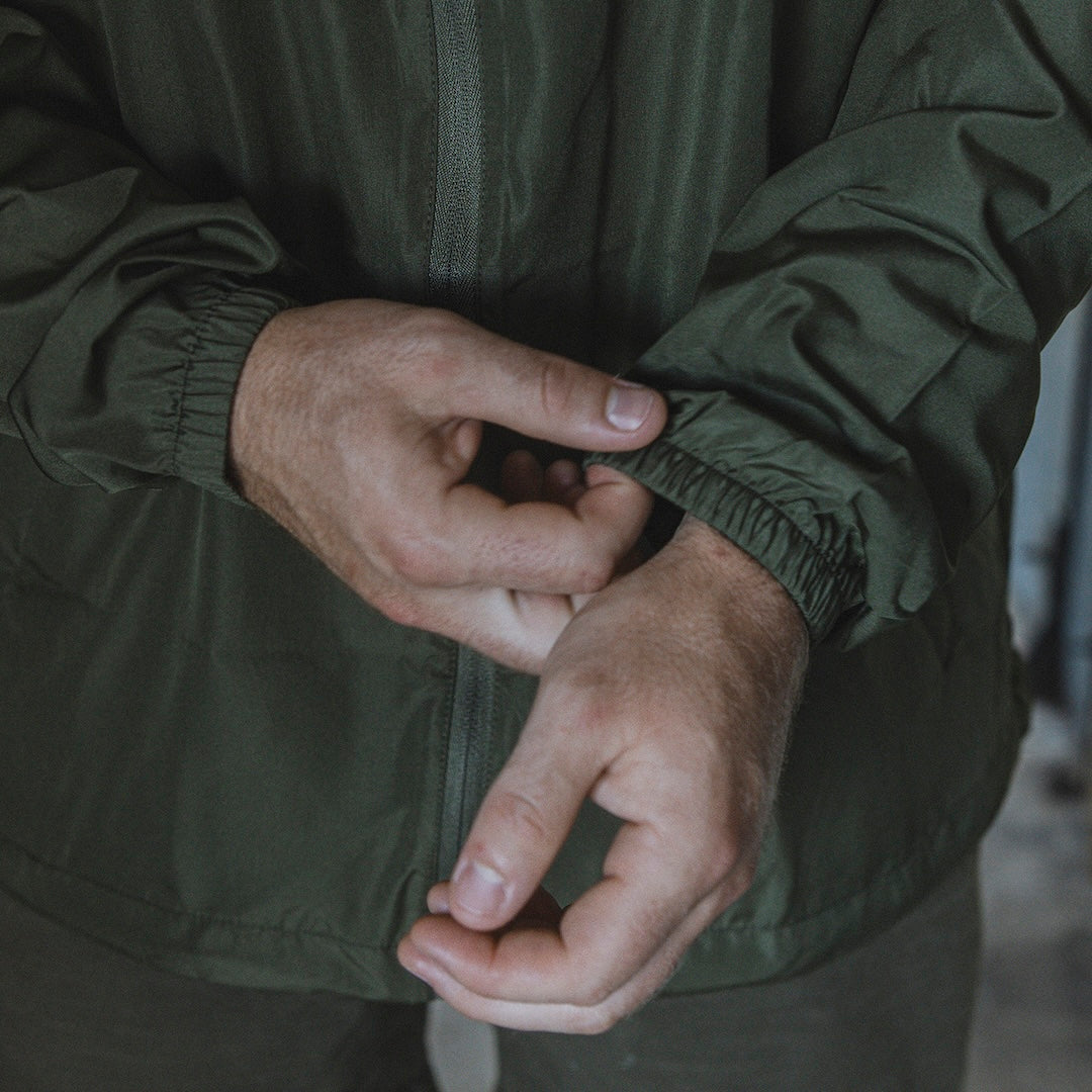 Man adjusting the cuffs and sleeves on a windbreaker