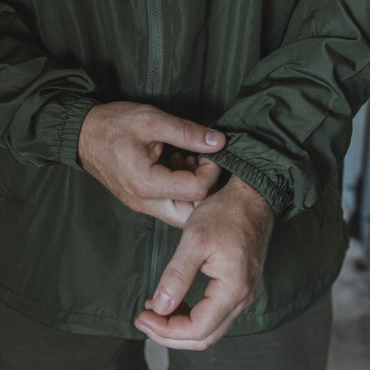 Man adjusting the cuffs and sleeves on a windbreaker