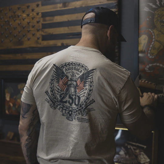 Man wearing the GBRS Group Semper Fortis Short Sleeve Shirt, standing in front of a wall with an American flag and other artwork.