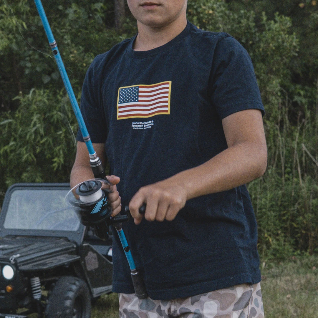 Child wearing the GBRS Group Navy Blue Youth Front & Center Short Sleeve Shirt, holding a fishing rod outdoors.