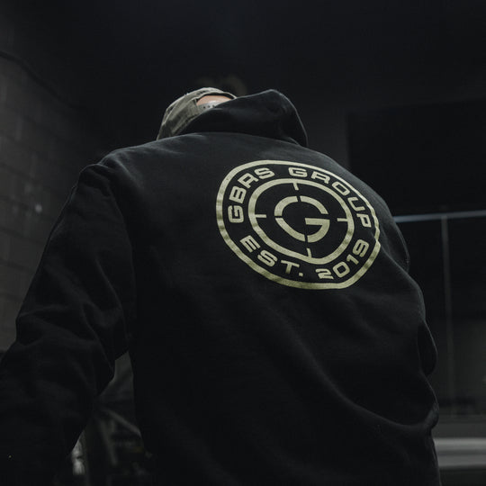 GBRS Group Instructor Pullover Hoodie, pictured in black in a gym lifestyle setting showing the backprint design