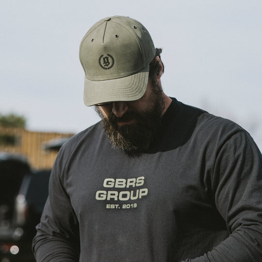 GBRS Group Legacy Canvas Trucker Hat in Loden. Front of hat pictured in lifestyle photo