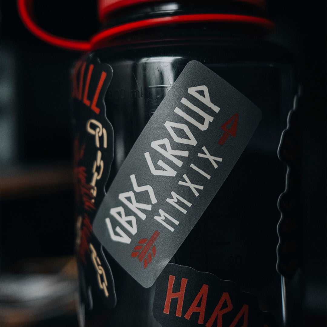 GBRS Group Hard to Kill Nalgene Water Bottle with GBRS Hard to Kill Stickers covering the bottle in a gym setting