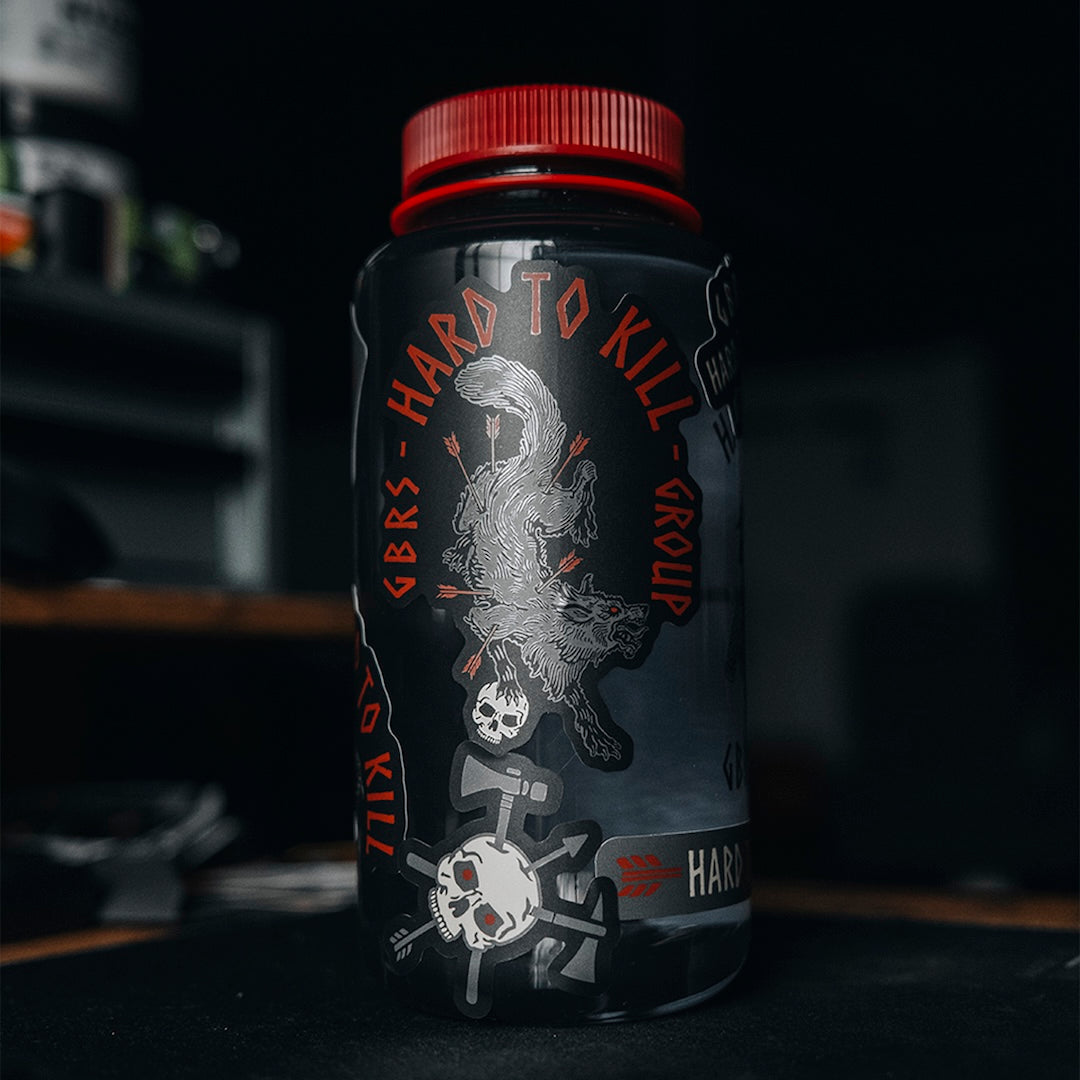 GBRS Group Hard to Kill Nalgene Water Bottle with GBRS Hard to Kill Stickers covering the bottle in a gym setting